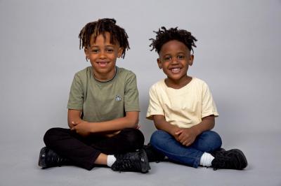 Two black brothers sitting together and smiling