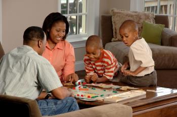 Black family playing a board game together