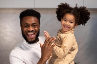 Black father and daughter smiling