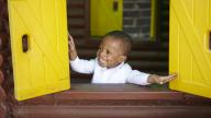 Happy little boy, black and ethnic minority heritage, in a play house