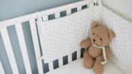 Baby's cot with teddy in the corner