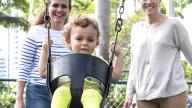 Same sex female couple with child in swing