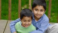 Two Indian brothers sitting in garden